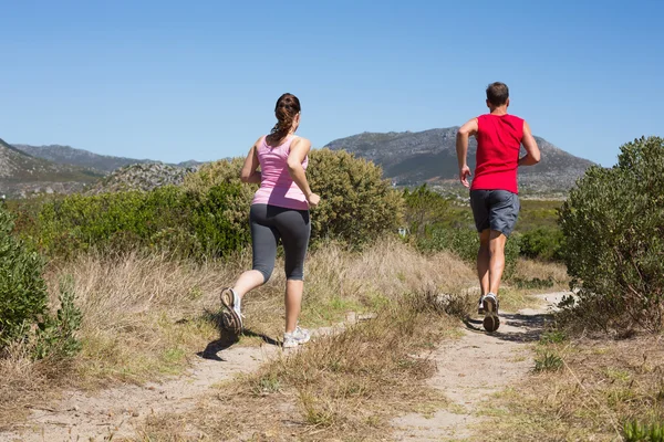 在国家地形上慢跑的活跃夫妇 — 图库照片