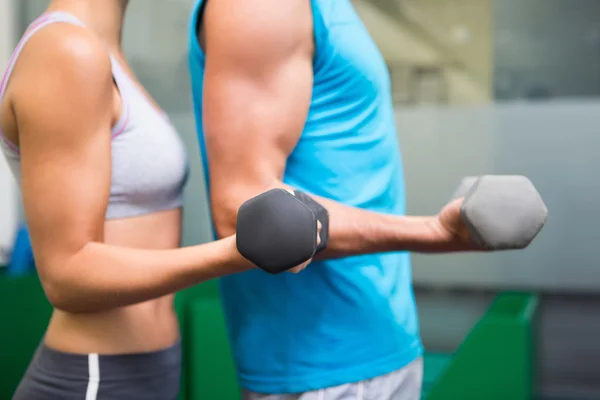 Fit couple lifting dumbbells together — Stock Photo, Image