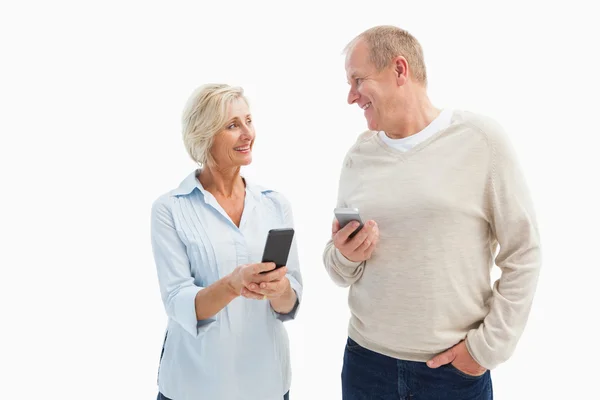 Gelukkige volwassen paar met behulp van hun smartphones — Stockfoto