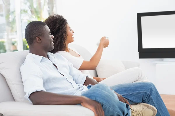 Para siedzi na kanapie razem oglądania telewizji — Zdjęcie stockowe
