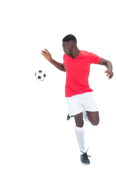 Joueur de football en maillot rouge contrôlant la balle — Photo