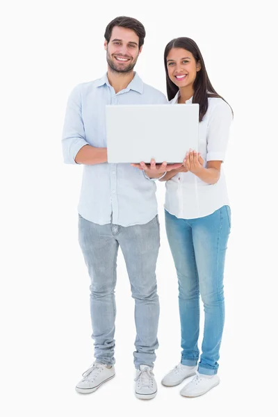 Pohledný mladý pár drží jejich laptop — Stock fotografie