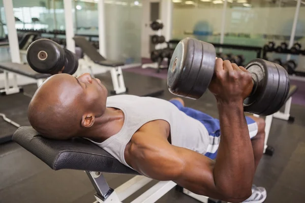 Uomo muscolare che si esercita con i manubri — Foto Stock