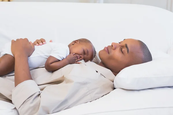 Felice giovane padre pisolino con bambino figlio sul divano — Foto Stock