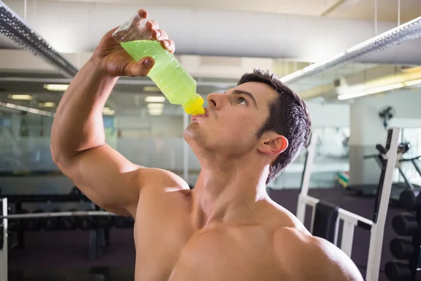 Jovem desportivo bebendo bebida energética no ginásio — Fotografia de Stock