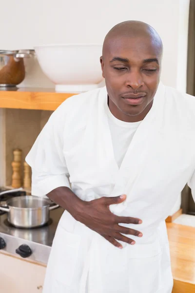 Homem doente de roupão de banho apertando o estômago — Fotografia de Stock