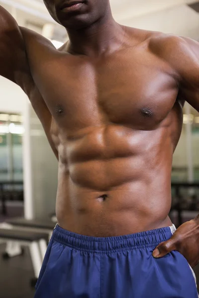 Средняя часть мускулистого мужчины без рубашки в спортзале — стоковое фото