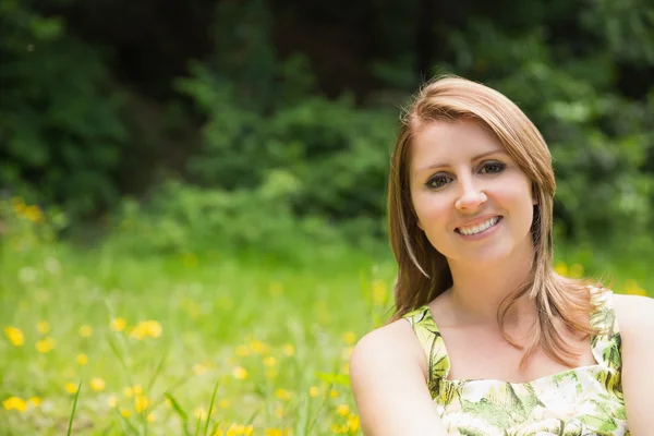 Cute young woman relaxing in field — Stock Photo, Image