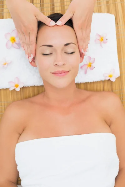 Morena sorridente desfrutando de uma massagem na cabeça — Fotografia de Stock