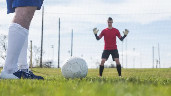 Portero en rojo esperando a que el delantero golpee la pelota — Foto de Stock