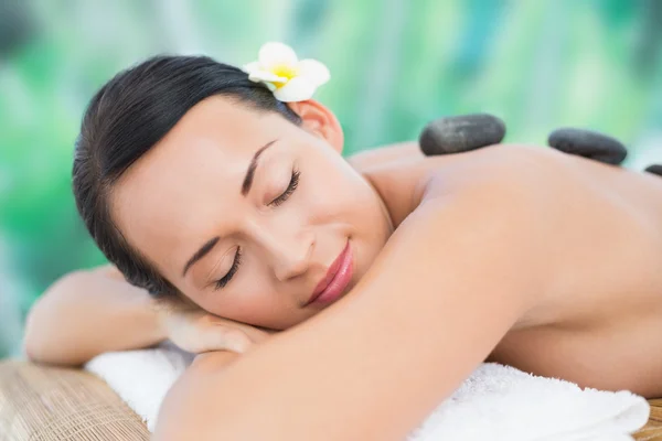 Brunette enjoying hot stone massage — Stock Photo, Image