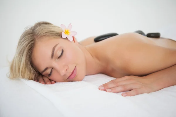 Loira bonita desfrutando de uma massagem de pedra quente — Fotografia de Stock