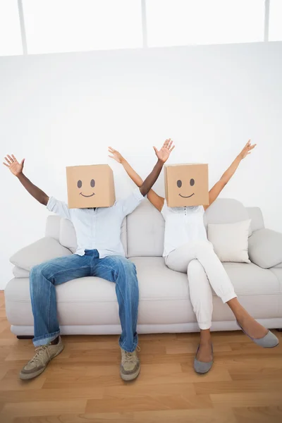 Couple sitting on couch together with boxes over head — Stock Photo, Image