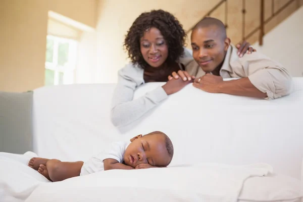 Baby boy sleeping peacefully on couch watched by parents — Stock Photo, Image