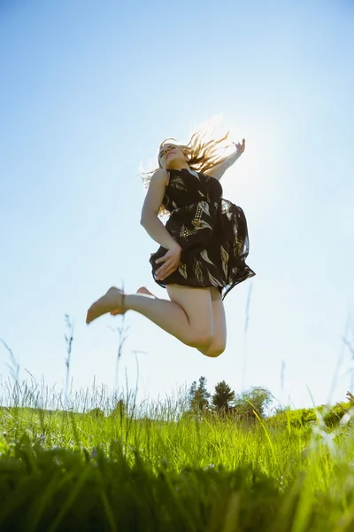 Pretty blonde in sundress jumping up Royalty Free Stock Photos