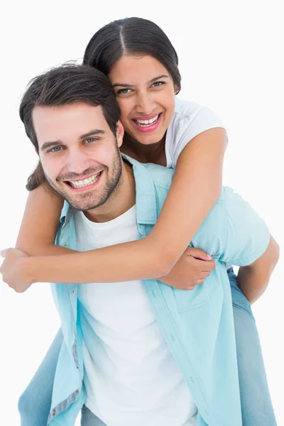 Happy casual man giving pretty girlfriend piggy back Stock Photo