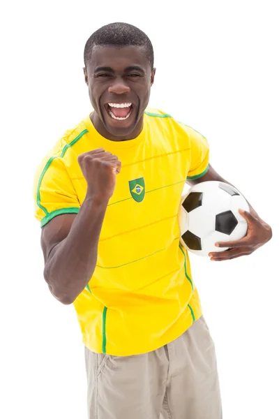 Excited brazilian football fan cheering holding ball Royalty Free Stock Images
