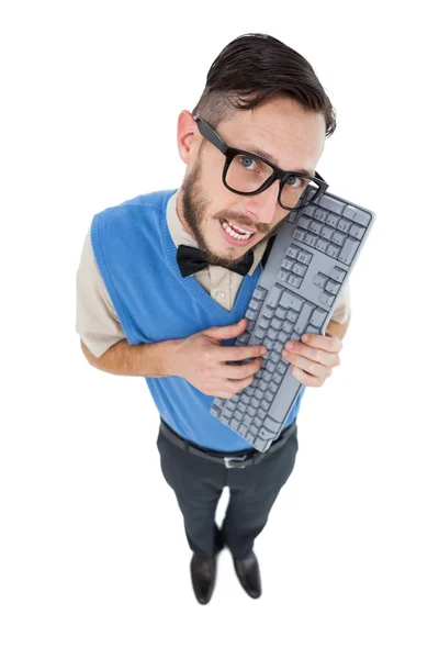 Geeky hipster looking at camera holding keyboard Stock Photo