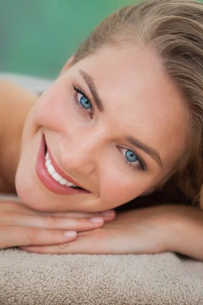 Pacífica rubia acostada sobre una toalla sonriendo a la cámara — Foto de Stock