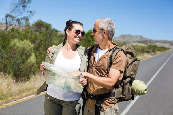 Coppia di escursionisti guardando la mappa sulla strada — Foto Stock