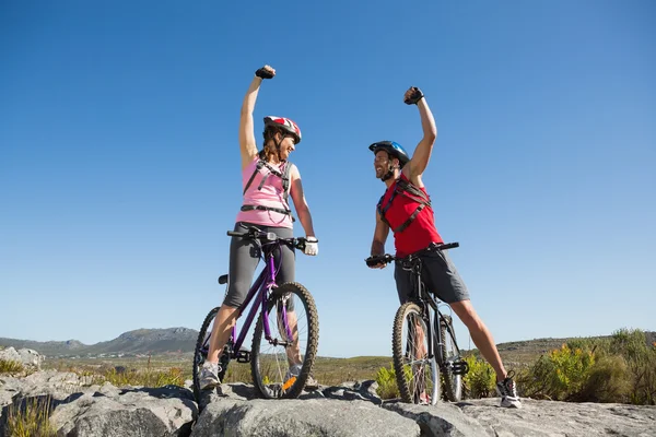 Ajuste ciclista pareja animando en la cumbre — Foto de Stock