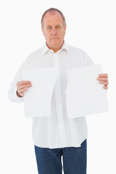 Hombre serio sosteniendo hoja rota de papel — Foto de Stock