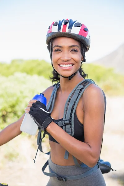 水のボトルを保持している自転車に乗るのために行く女性に適合します。 — Stockfoto