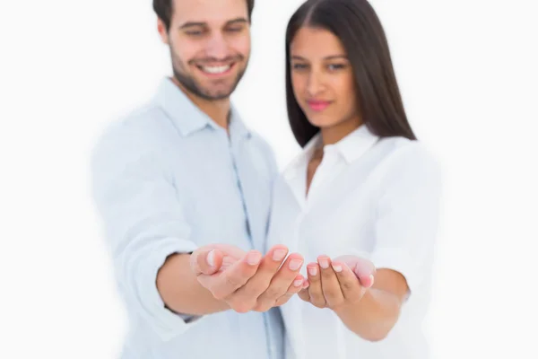 Attractive young couple holding their hands out — Stock Photo, Image