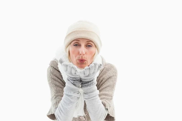 Volwassen vrouw in winterkleren blazen kus — Stockfoto