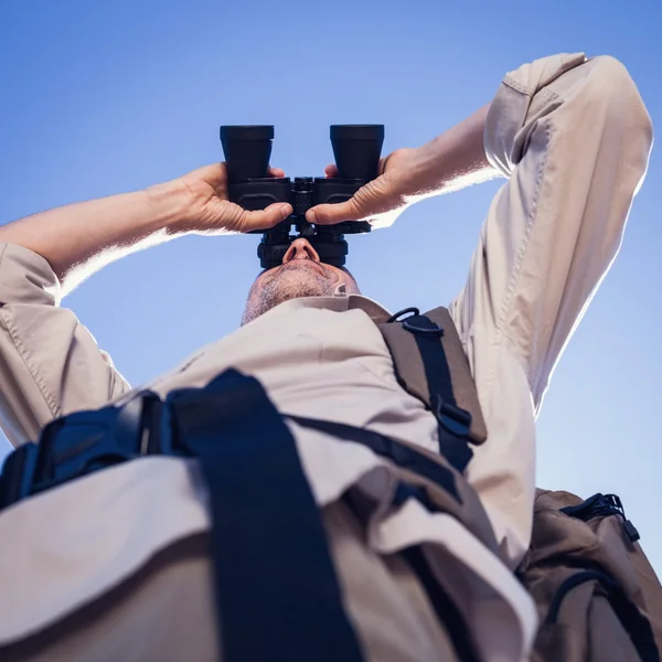 Wanderer blickt mit Fernglas auf Feldweg — Stockfoto