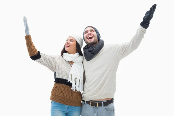 Atractiva pareja joven en ropa de abrigo con los brazos arriba — Foto de Stock