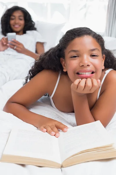 Gelukkig moeder en dochter ontspannen op bed samen — Stockfoto