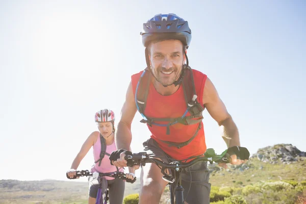 Fit cyclist couple riding together on mountain trail — Stock Photo, Image