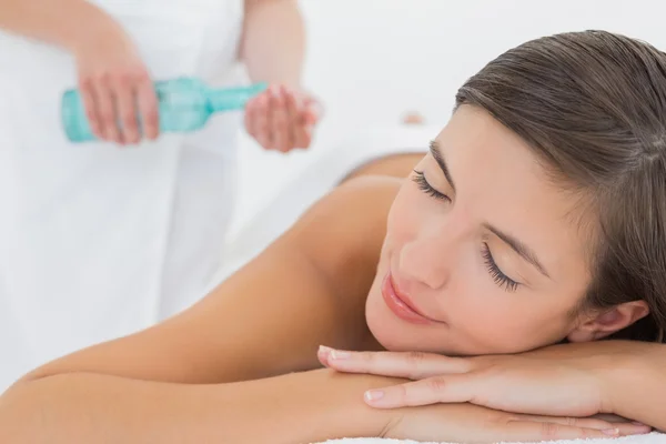 Atractiva mujer recibiendo aceite de masaje en su espalda — Foto de Stock