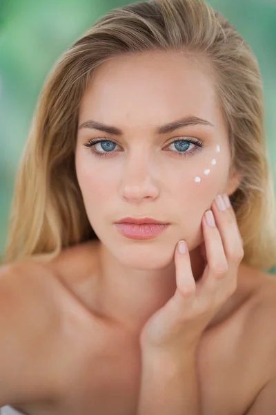 Beautiful natural blonde looking at camera with eye cream on — Stock Photo, Image