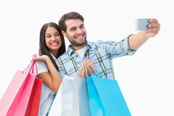 Attraente giovane coppia con shopping bags prendere un selfie — Foto Stock