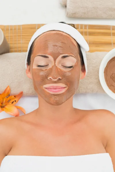 Smiling brunette getting a mud treatment facial — Stock Photo, Image