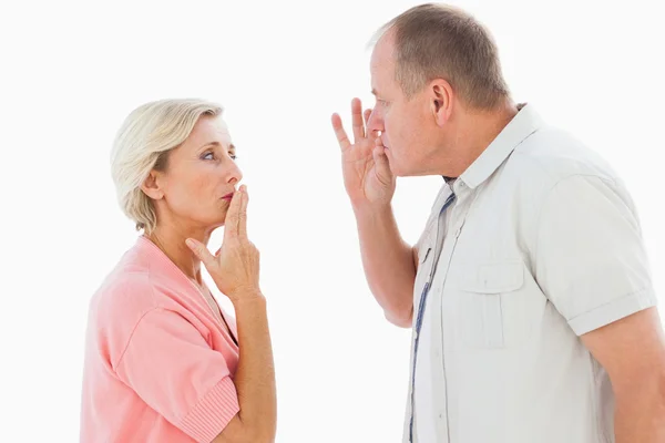 Older couple holding hands to mouth for silence — Stock Photo, Image