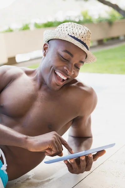 Bello uomo senza camicia che utilizza tablet pc a bordo piscina — Foto Stock