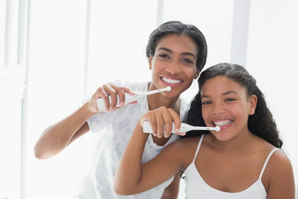 Bonita mãe escovando os dentes com sua filha — Fotografia de Stock