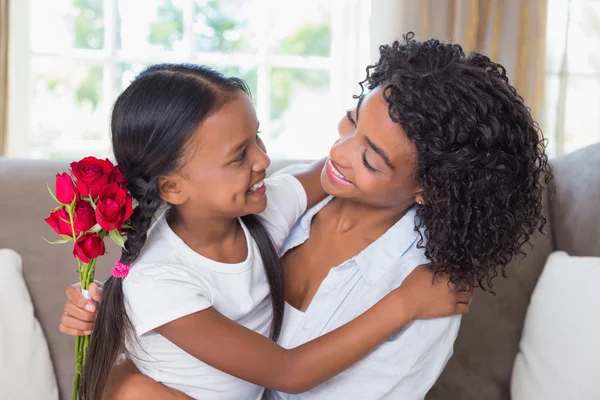 Hübsche Mutter mit ihrer Tochter, die Rosen hält — Stockfoto