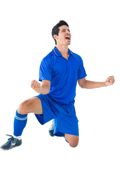Счастливый футболист в голубом празднует — стоковое фото