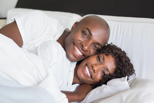 Casal feliz deitado na cama juntos — Fotografia de Stock