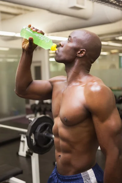 Gespierde man energiedrank drinken in de sportschool — Stockfoto