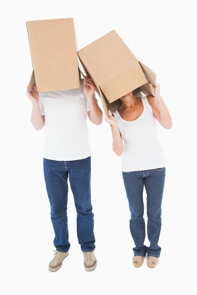 Couple d'âge mûr portant des boîtes sur la tête — Photo