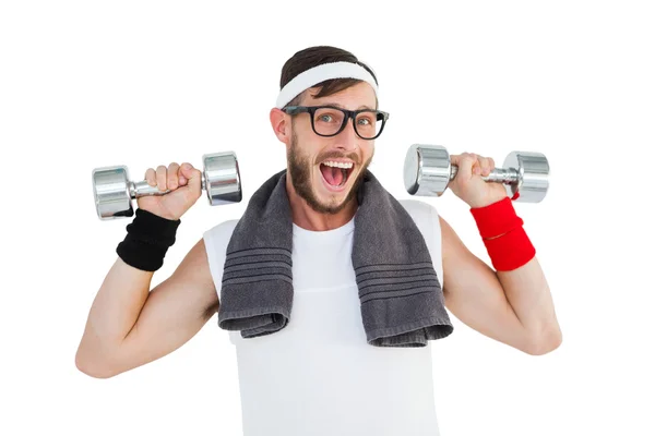 Geeky hipster lifting dumbbells in sportswear — Stock Photo, Image