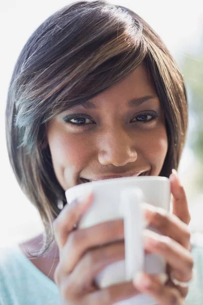 Ładna kobieta siedzi poza filiżankę kawy — Zdjęcie stockowe