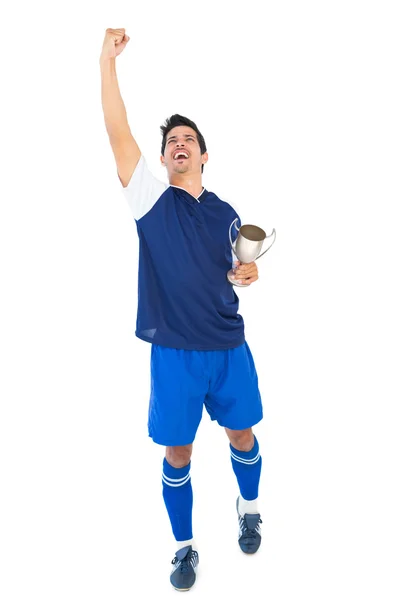 Jogador de futebol em azul segurando copo vencedores — Fotografia de Stock