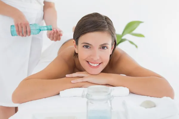 Atractiva mujer recibiendo aceite de masaje en su espalda — Foto de Stock