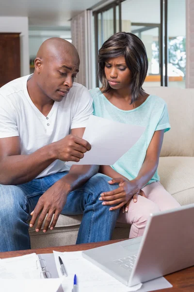 Worried couple calculating bills on the couch — Stock Photo, Image